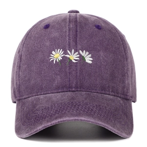 Dettaglio di tre ricami di margherite su cappello in cotone lavato viola scuro vintage