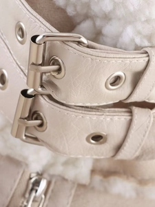 Detail of faux leather biker jacket with silver metal buckle and soft shearling lining