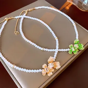 Elegant gold plated pearl necklace with colorful flower pendants in green and amber