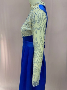 Detail of royal blue evening gown showing sequin embroidery and sheer mesh sleeves