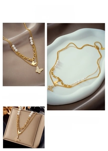 Close-up of double-layered gold butterfly necklace with pearls and irregular chain