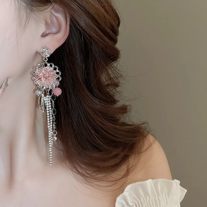 Macro detail of long tassel floral earrings with pink crystals and silver rhinestone fringe