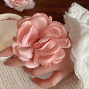 Detailansicht der rosa Seidenblumenring-Struktur mit weichen Satinschichten und Eleganz