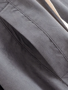 Close-up of deep gray fabric texture with pocket stitching and white drawstring detail