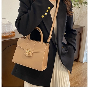 Détail du sac à main beige structuré avec fermoir fleur dorée et bandoulière fine