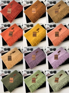 Multiple color options of thick cashmere-like scarves with fringe and leather tags