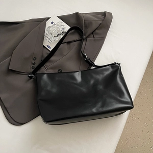 Vue détaillée du sac cabas minimaliste en cuir PU noir sur un fond élégant et doux