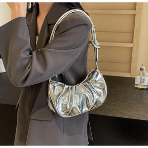 Detail of silver cloud pleated bag showing knot detail and shiny metallic texture