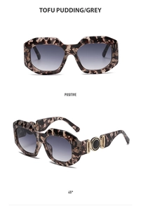 Detail view of retro sunglasses with marble frames and decorative gold metal temples