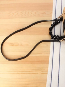 Sac tressé avec perles en bois et bandoulière en cuir noir dotée de fermoirs dorés