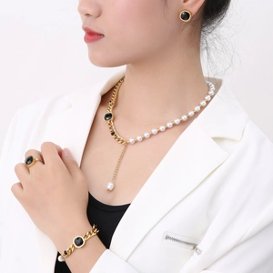 Macro detail of gold-plated jewelry set with black gemstones and elegant white pearls
