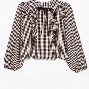 Plaid long sleeve blouse with ruffle trim and bow tie neck on white background