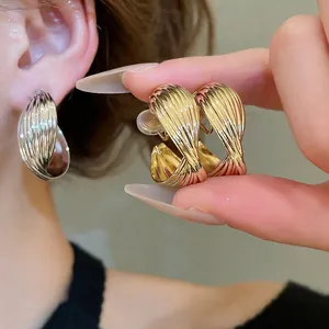 Elegant twisted spiral hoop earrings in gold and silver finish for a modern look