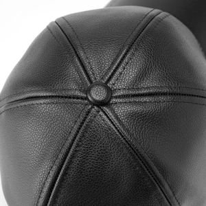 Close-up of black litchi grain leather texture and durable stitching on a baseball cap