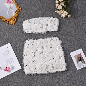 Detail of white sequin and feather two-piece set featuring crop top and bodycon skirt