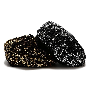 Detail of gold and black sequined velvet beret hats with reflective sparkling texture
