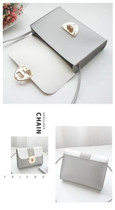 Detail view of grey and white PU leather crossbody bag with gold lock and interior space