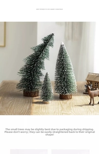 Detail of mini snow-flocked Christmas trees with natural wood bases for table decoration
