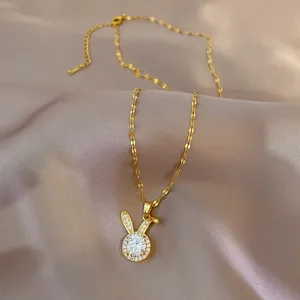 Close-up of a rabbit pendant necklace with zircon crystals on pink satin fabric