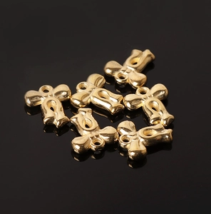 Macro shot of six metallic gold bow charms on a reflective black background