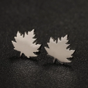 Macro detail of silver maple leaf stud earrings made of polished stainless steel