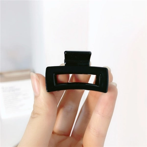 Close-up of a glossy black rectangular hollow hair claw clip with a secure grip