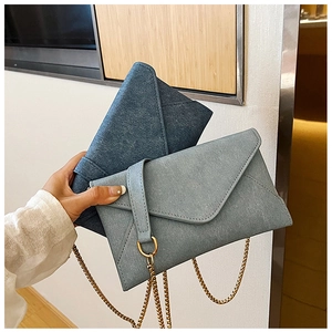 Close-up of envelope crossbody bags with gold D-ring hardware and chain strap details