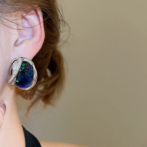 Gros plan sur boucle d'oreille vintage en résine avec pierre bleue et détails zircon