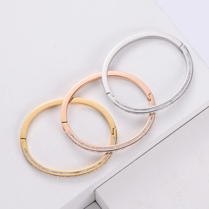 Close-up of three-color stacked bangles with micro-pave cubic zirconia in 18K gold plating