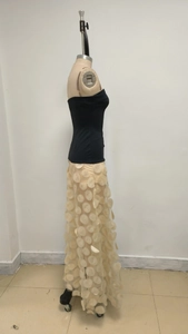 Detail of elegant black tube top paired with a beige polka dot mesh maxi skirt