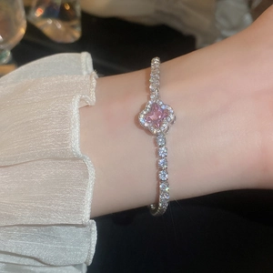 Detail of pink heart zircon bracelet on model wrist with shimmering metal chain