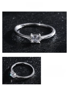 Macro shot of silver ring with square-cut zircon and side accents on a textured base
