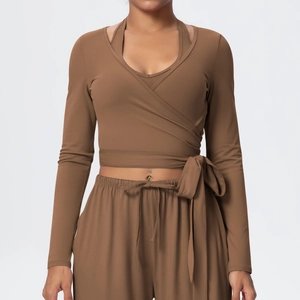 Detail of V-neck long sleeve yoga top with cross tie waist and elastic waistband