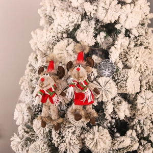Cute reindeer Christmas hanging ornaments with red sweaters and scarves on snowy tree