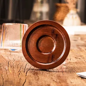 Hand-painted rotating whiskey glass with creative wooden spinning base on a rustic table