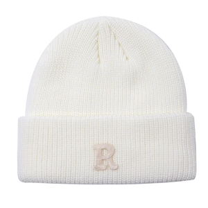 Detail der R-Buchstaben-Stickerei auf cremeweißer Rippstrickmütze für den Winter