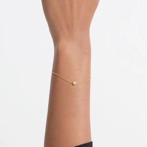 Close-up of a minimalist S925 sterling silver thin gold chain bracelet with a round zircon