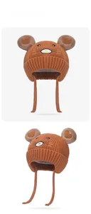 Détail du bonnet en tricot pour bébé avec cache-oreilles et broderie de souris