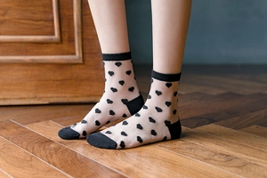 Dettaglio di calze in tulle nero con cuori floccati e tallone rinforzato resistente
