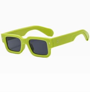Détail de lunettes de soleil carrées vert néon avec rivets argentés et verres foncés
