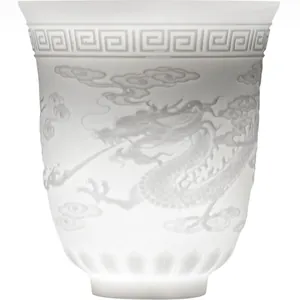 Translucent white porcelain teacup with embossed dragon patterns and lotus base