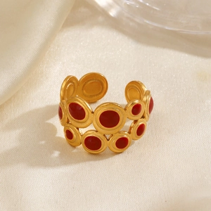 Vintage gold geometric ring with red enamel details on a beige velvet background