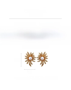 Close-up of golden sunflower earrings with sparkling zircons and a white pearl center