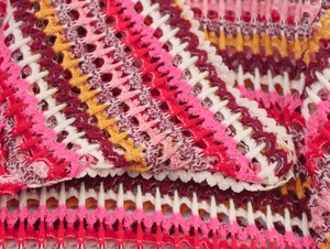 Close-up of colorful wavy crochet knit pattern on a polo shirt and shorts set