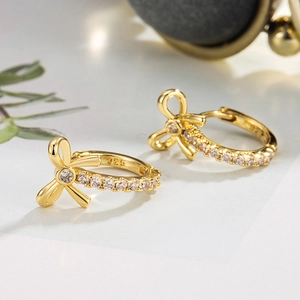 Gold bow earrings with white zircon accents and 925 sterling silver hallmark details
