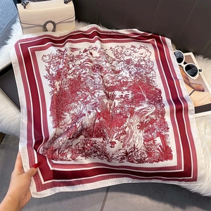 Macro detail of elegant red landscape print silk scarf on plush white background