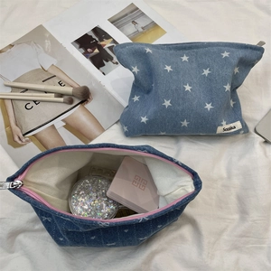 Détail de trousses à maquillage en jean avec étoiles blanches et fermetures éclair roses