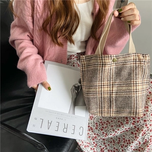 Vintage checkered plaid woolen handbag carried by a model in a cozy lifestyle setting