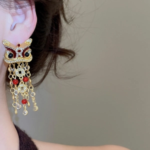 Détail de boucles d'oreilles lion chinois avec émail, zircon et pompon porté par modèle