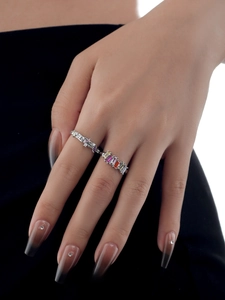 Detail showing two-piece silver ring set with colorful baguette gemstones on hands